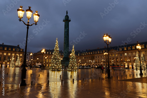 Vendome column with statue of Napoleon Bonaparte  on the Place Vendome decorated for Christmas at rainy night   Paris  France.