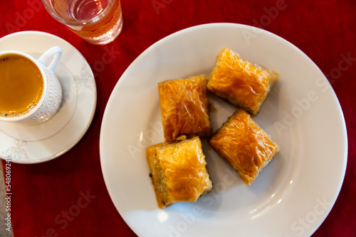 Traditional Turkish dessert - baklava on a plate and a cup of coffee