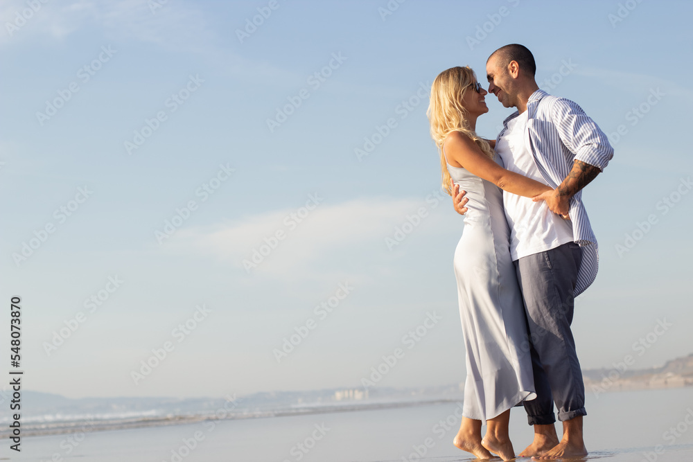 Affectionate couple in love at beach. Husband and wife in casual clothes hugging and dancing on summer day. Vacation, happiness, relationship concept