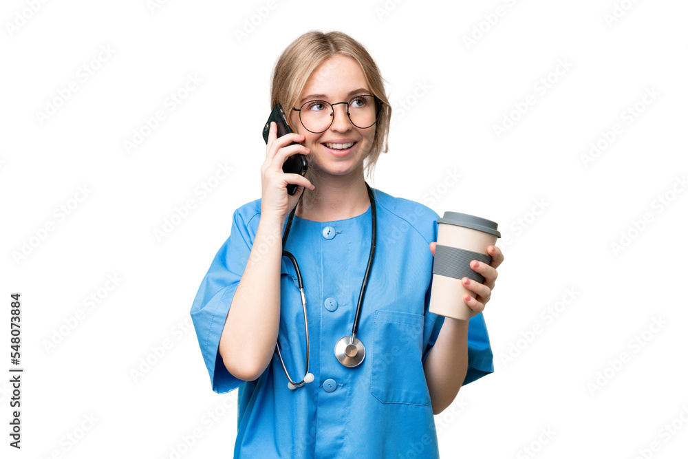 Young nurse English woman over isolated background holding coffee to take away and a mobile Young nurse English woman over isolated background holding coffee to take away and a mobile