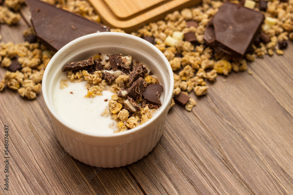 Granola in a bowl surrounded by granola on table. Granola background Granola in a bowl surrounded by granola on table. Granola background