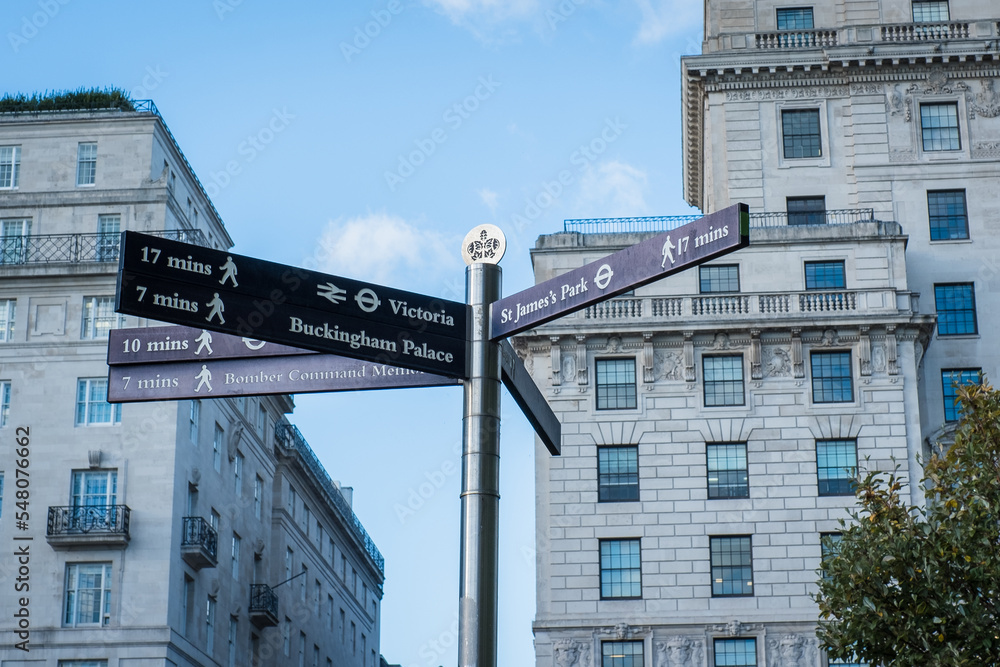 Guide arrows showing different popular directions and walking distances in London city tourist area. London sightseeing signpost. Guide arrows showing different popular directions and walking distances in London city tourist area. London sightseeing signpost.