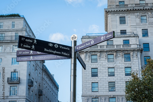 Guide arrows showing different popular directions and walking distances in London city tourist area. London sightseeing signpost. © Cloudy Design