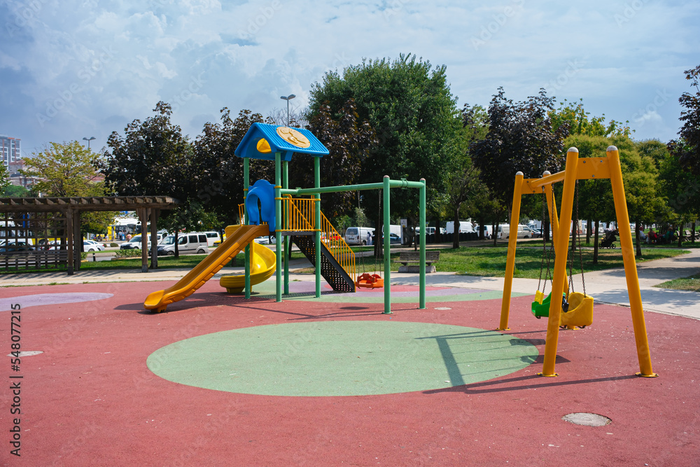 Children playground, swing in the park for children in public park. small empty colorful playground in the city Children playground, swing in the park for children in public park. small empty colorful playground in the city