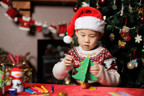young girl making Christmas tree craft at home