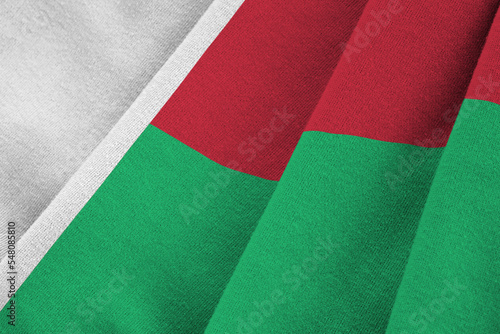 Madagascar flag with big folds waving close up under the studio light indoors. The official symbols and colors in banner photo