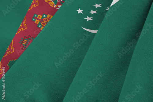 Turkmenistan flag with big folds waving close up under the studio light indoors. The official symbols and colors in banner photo