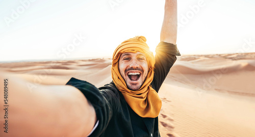 Fotografia Happy male tourist taking selfie on sand dunes in the Africa desert, Sahara Nati