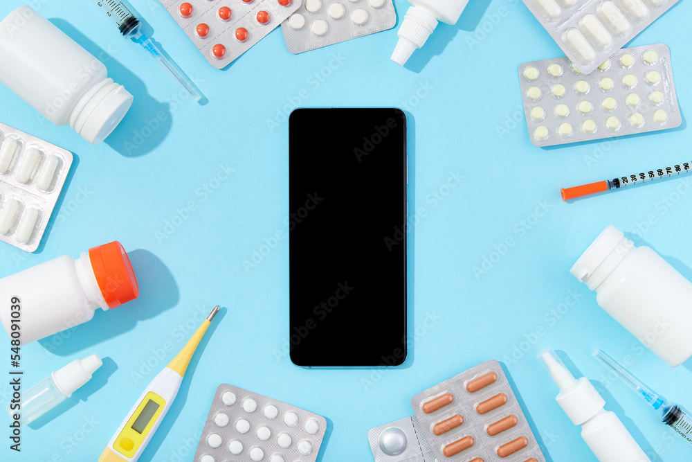 Different medicine pills and smartphone. Buying online drug delivery concept Different medicine pills and smartphone. Buying online drug delivery concept