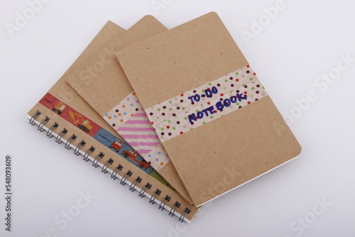 DIY plain brown notebooks with washi tape on cover against a white background