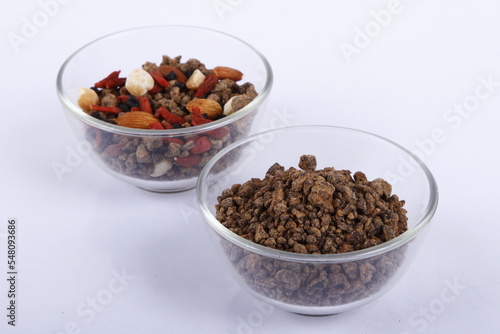 Bowls of assorted nuts and muscovado rocks against a white background