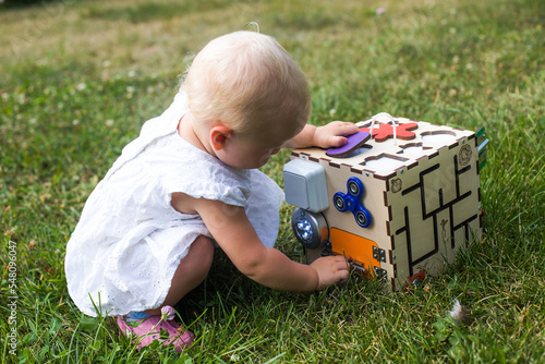 The child wants to open the door with a pawl on the developing cube. photo