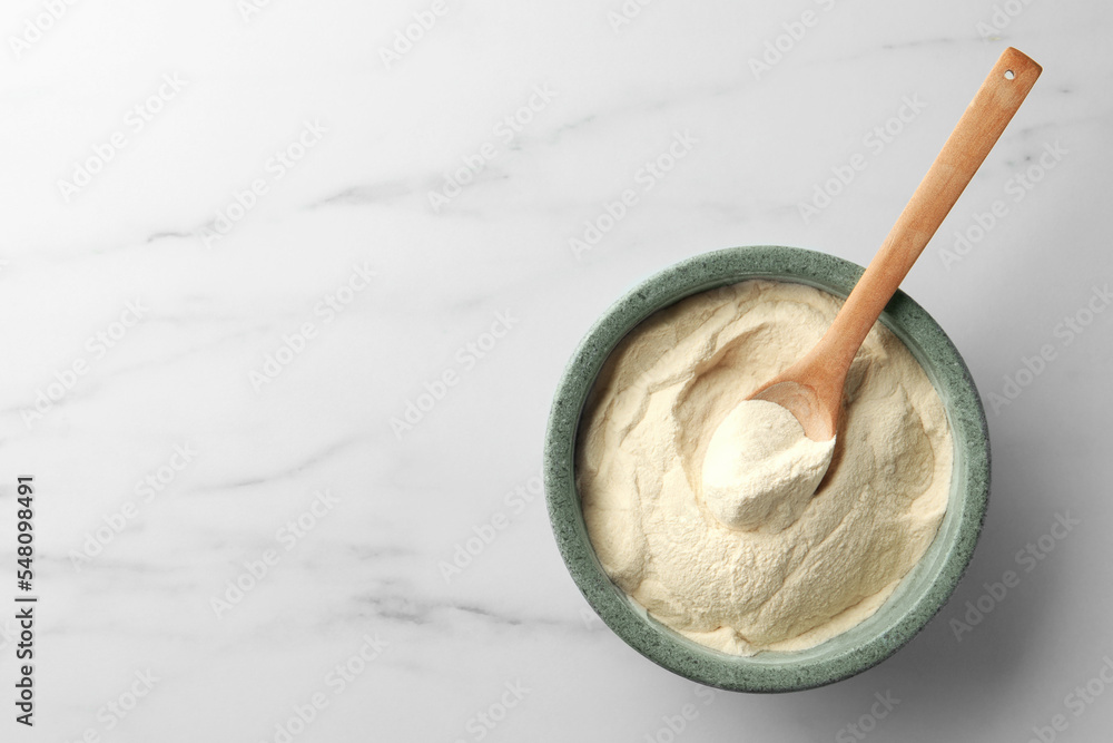 Bowl and spoon of agar-agar powder on white marble table, top view. Space for text Bowl and spoon of agar-agar powder on white marble table, top view. Space for text