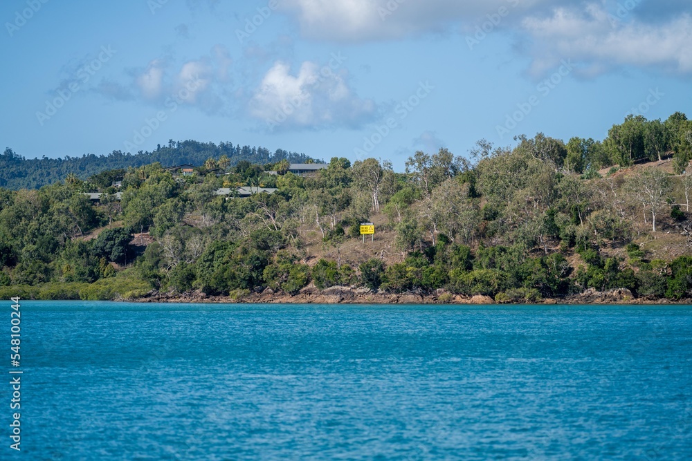 tourist boats and tour boats in the whitsundays queensland, australia. travellers on the great barrier reef, over coral and fish. tourism yachts of young people partying on the water