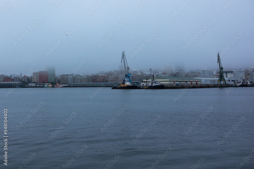 A commercial port for ships in the city in heavy fog views from the water.