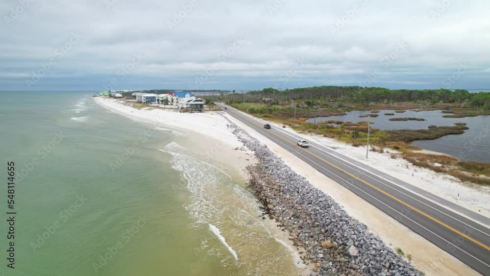 Aerial pull-away following road with waves crashing against rock barrier in Cape San Blas, Florida Aerial pull-away following road with waves crashing against rock barrier in Cape San Blas, Florida