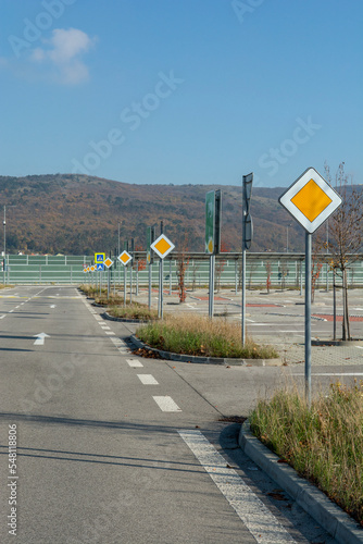 International road signs 'Main road' or 'Priority road' in a row. Many  yellow squares signs. photo