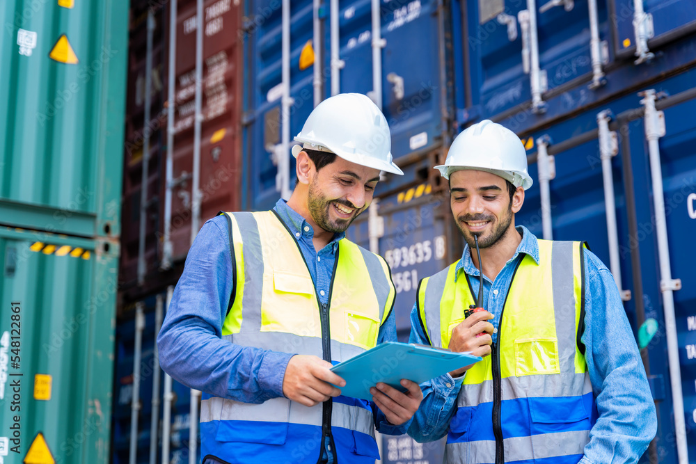 Two male engineers in a container shipping company Consulting to check the order for the container that is responsible
Two male engineers in a container shipping company Consulting to check the order for the container that is responsible