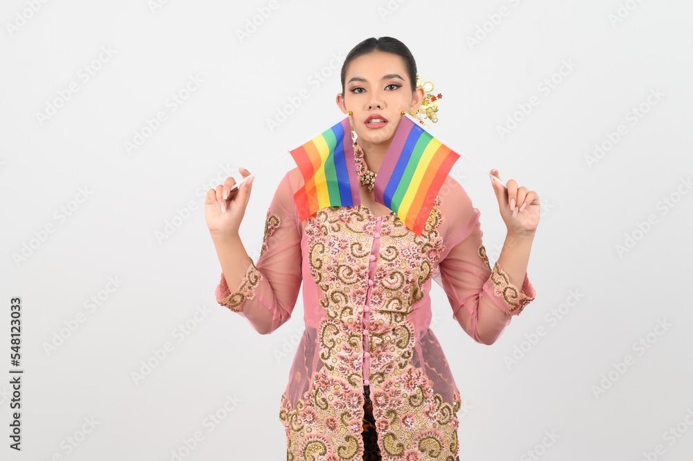 Young beautiful woman dress up in local culture in southern region with rainbow flag Young beautiful woman dress up in local culture in southern region with rainbow flag