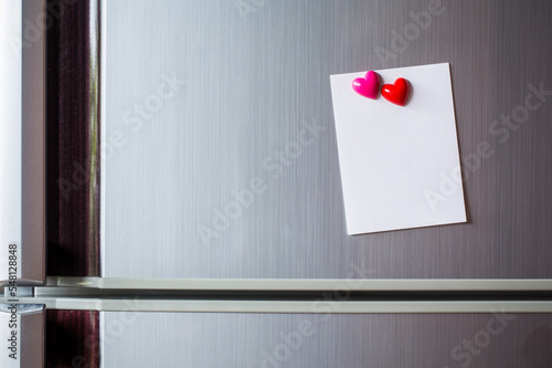 Abstract of wooden heart clip with Blank paper and stick paper on refrigerator door. paper note copy space for add text. valentine picture message background