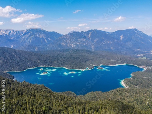 Aerial view of Elbsee lake surrounded by dense trees and mountains photo