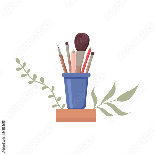 A set of makeup brushes in a glass