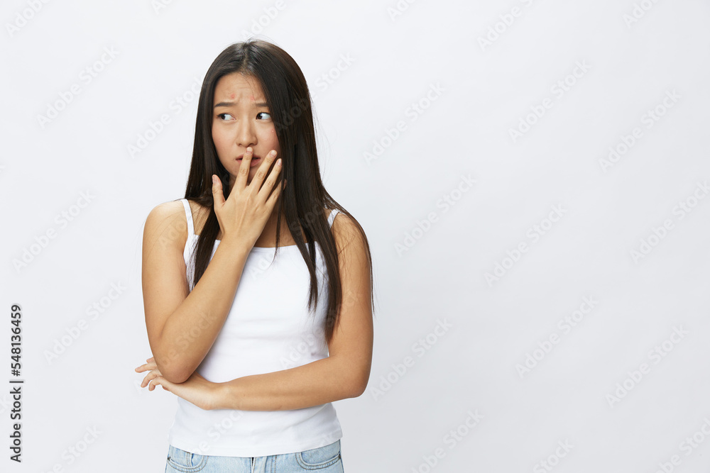 Asian woman hand signals, finger pointing facial skin problems, acne and inflammation, red rash and allergies, chicken pox, sadness from rashes. Facial skin care concept for diseases and nerves Asian woman hand signals, finger pointing facial skin problems, acne and inflammation, red rash and allergies, chicken pox, sadness from rashes. Facial skin care concept for diseases and nerves