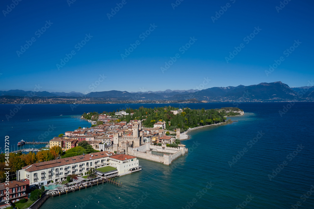 Lake Garda, a tourist destination in northern Italy. Top view of the town of Sirmione, Italy. Autumn in Italy on Lake Garda, Sirmione peninsula. Trees in the autumn season.