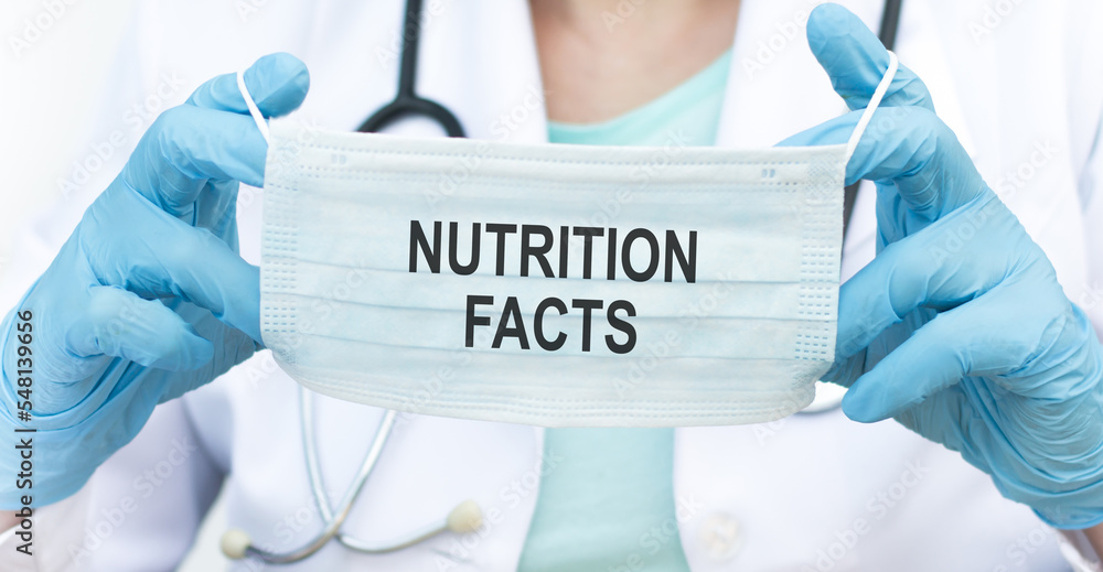 Nutrition Facts - doctor holds a blue face mask with inscription, medical concept Nutrition Facts - doctor holds a blue face mask with inscription, medical concept