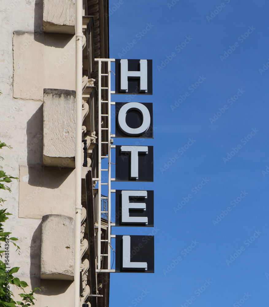 Hotel sign in Paris, France, with a blue sky background. Hotel sign in Paris, France, with a blue sky background.