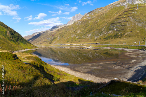 Beautiful landscape at Oberalppass with lake and reflections of mountain panorama on a sunny late summer day. Photo taken September 5th  2022  Oberalp Pass  Switzerland.