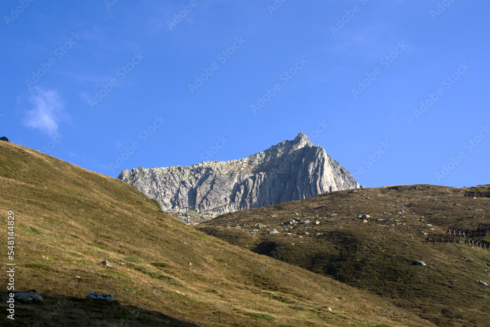 Fototapeta premium Mountain panorama with peak at Swiss mountain pass Oberalppass on a sunny late summer morning. Photo taken September 5th, 2022, Oberalp Pass, Switzerland.