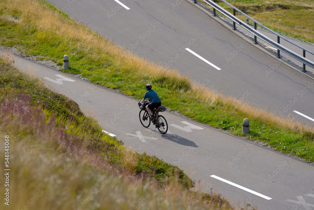 Aerial view of mountain pass road and tour cyclist at Swiss mountain pass Oberalppass on a late summer day. Photo taken September 5th, 2022, Oberalp Pass, Switzerland.