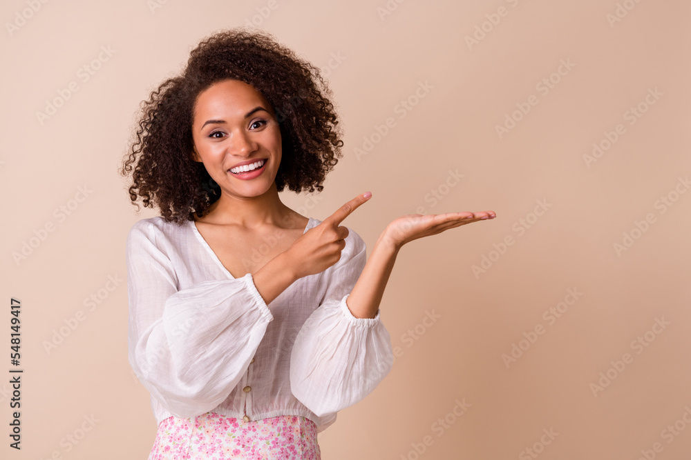 Portrait of nice lovely girl indicate finger hand palm hold empty space promotion isolated on beige color background Portrait of nice lovely girl indicate finger hand palm hold empty space promotion isolated on beige color background