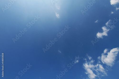 blue sky with minimal clouds with sunshining ray on at noon