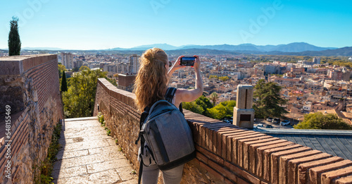 Woman tourist taking photography at Girona,  panoramic view of the city- Spain photo