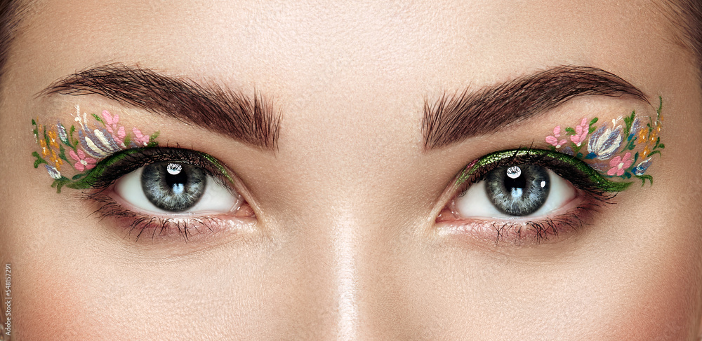 Obraz premium Female eye with flower makeup eyes. Spring makeup. Beauty fashion. Eyelashes. Cosmetic Eyeshadow. Make-up detail. Close up, Macro