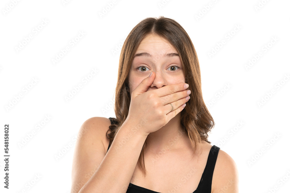 Shocked Embarrassed Young Woman Covering Mouth On A White Background Shocked Embarrassed Young Woman Covering Mouth On A White Background