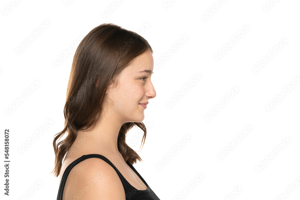Profile of a beautiful young smiling women with long hair and no makeup on a white background. Profile of a beautiful young smiling women with long hair and no makeup on a white background.