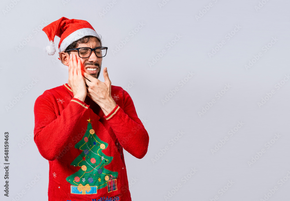 Man in christmas sweater with toothache, Young man in christmas hat with toothache isolated, Man in christmas hat in pain touching his tooth. Christmas toothache concept Man in christmas sweater with toothache, Young man in christmas hat with toothache isolated, Man in christmas hat in pain touching his tooth. Christmas toothache concept