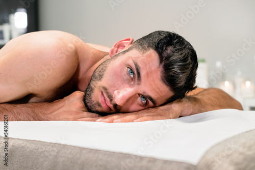 Young man lying on massage table