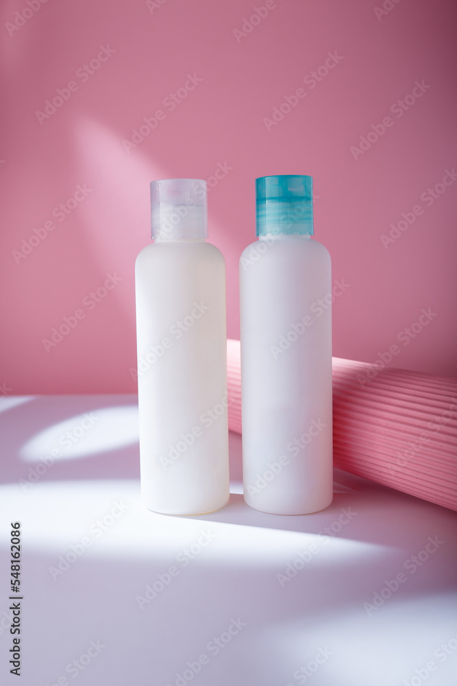 Hair conditioner and shampoo mockup bottles, white template containers on pink background, harsh light. Care cosmetics no brand Hair conditioner and shampoo mockup bottles, white template containers on pink background, harsh light. Care cosmetics no brand