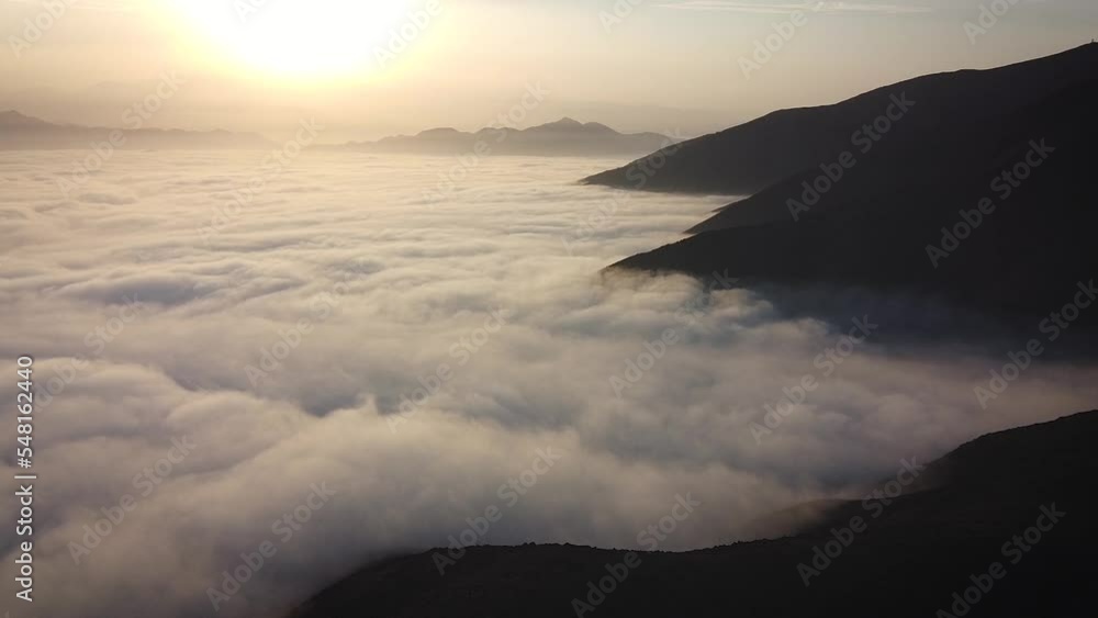 Above the clouds and the mountains of Lima Peru during an orange sunrise Above the clouds and the mountains of Lima Peru during an orange sunrise