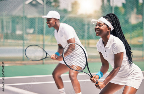 Tennis, sports and competition with a black woman and doubles partner playing a game on a court outdoor together. Fitness, team and exercise with a man and female tennis player at a venue for sport © L Ismail/peopleimages.com