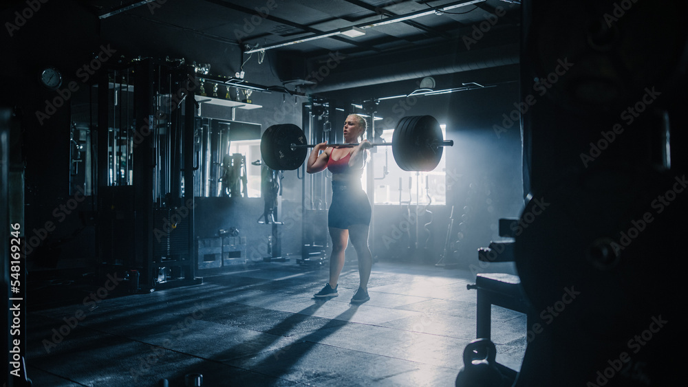 Inspiring Young Athlete Powerlifting and Exercising in a Deserted Hardcore Gym. A Future Female Champion Training Hard with Barbell Workout for Competition. She is Lifting Heavy Weights to Workout Inspiring Young Athlete Powerlifting and Exercising in a Deserted Hardcore Gym. A Future Female Champion Training Hard with Barbell Workout for Competition. She is Lifting Heavy Weights to Workout