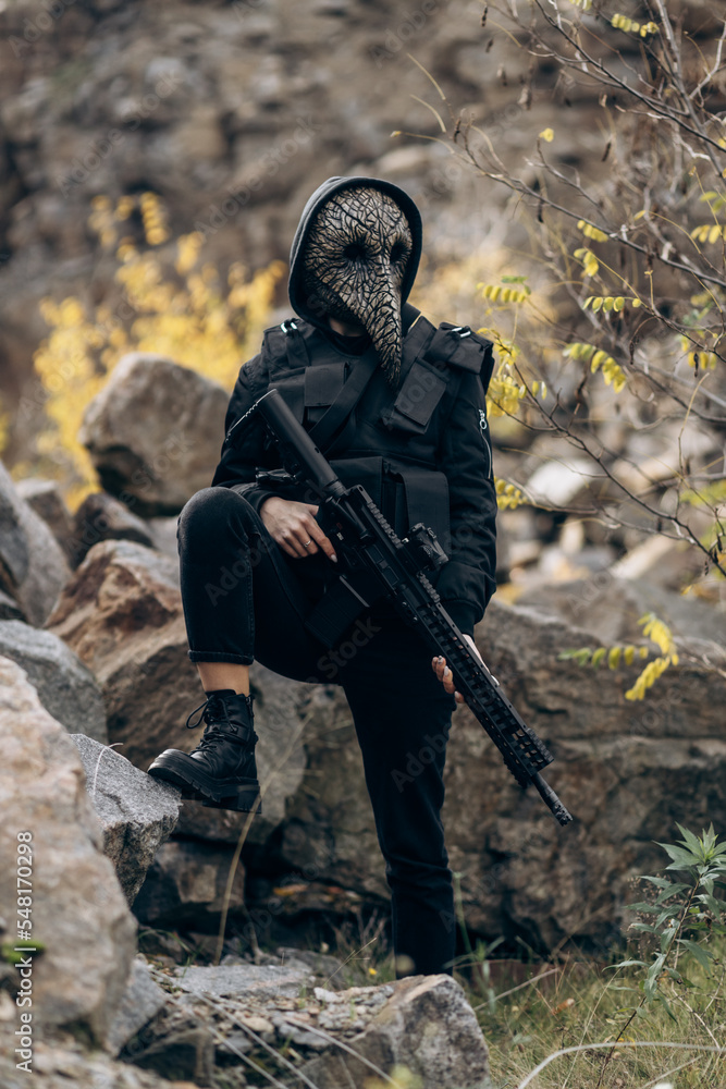 Naklejka premium Commando in mask and with machine gun among mountains.