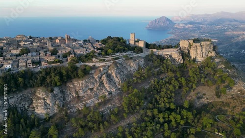 Aerial view of the old town and the ruins of the castle in the small town of Erice. In the background the Mediterranean Sea and mountains. The moment before sunset. Golden hour. Sicily. Italy