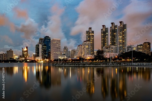 Cityscape of Bangkok skyscrapers and city lights with their reflection on a lake at night, Thailand photo