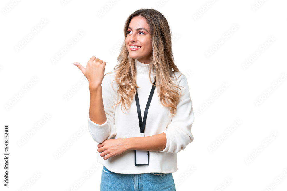 Young Uruguayan woman with ID card over isolated background pointing to the side to present a product Young Uruguayan woman with ID card over isolated background pointing to the side to present a product