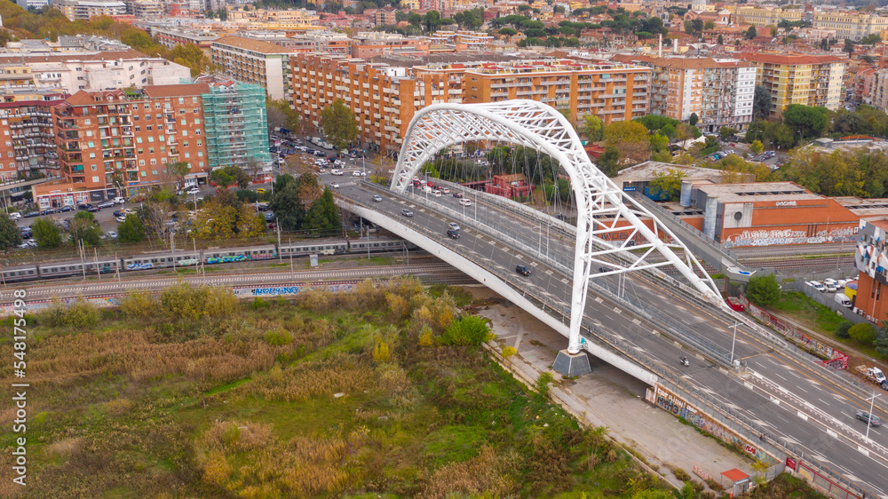 Fototapeta premium Aerial view of the Settimia Spizzichino bridge known as Ostiense overpass. This iron arch bridge is located in the Garbatella district in Rome, Italy